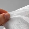 How to recognize quality toilet paper? - A hand separates the layers of white toilet paper to show the thickness and embossed texture. - Luu